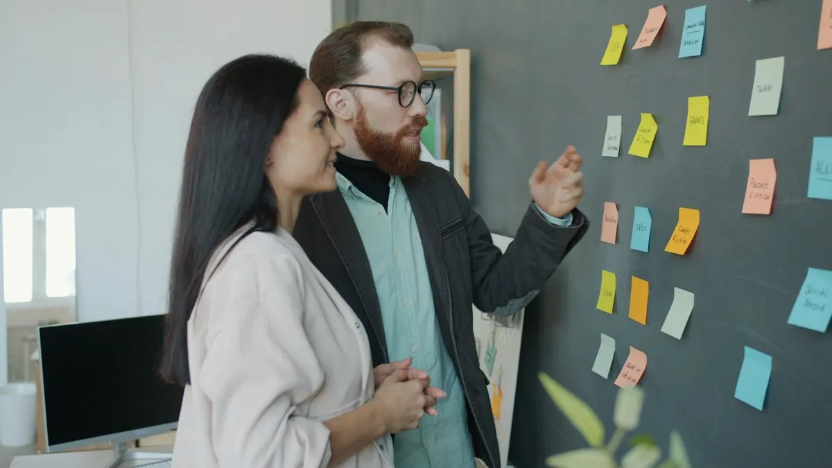 Due colleghi davanti a una bacheca di post-it